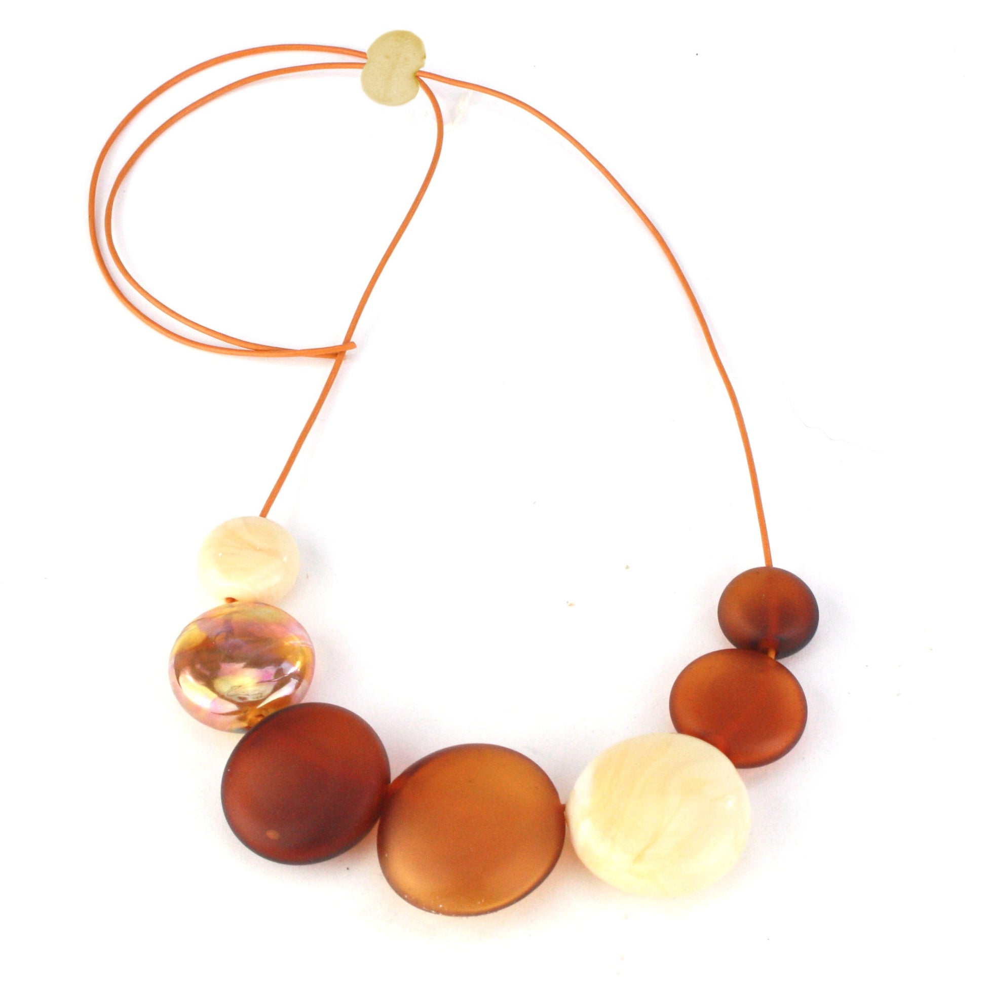 A handcrafted necklace featuring seven hollow hand-blown glass beads in amber, ivory, and gold hues, strung on adjustable leather for a versatile, elegant look.