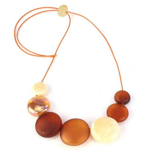 A handcrafted necklace featuring seven hollow hand-blown glass beads in amber, ivory, and gold hues, strung on adjustable leather for a versatile, elegant look.