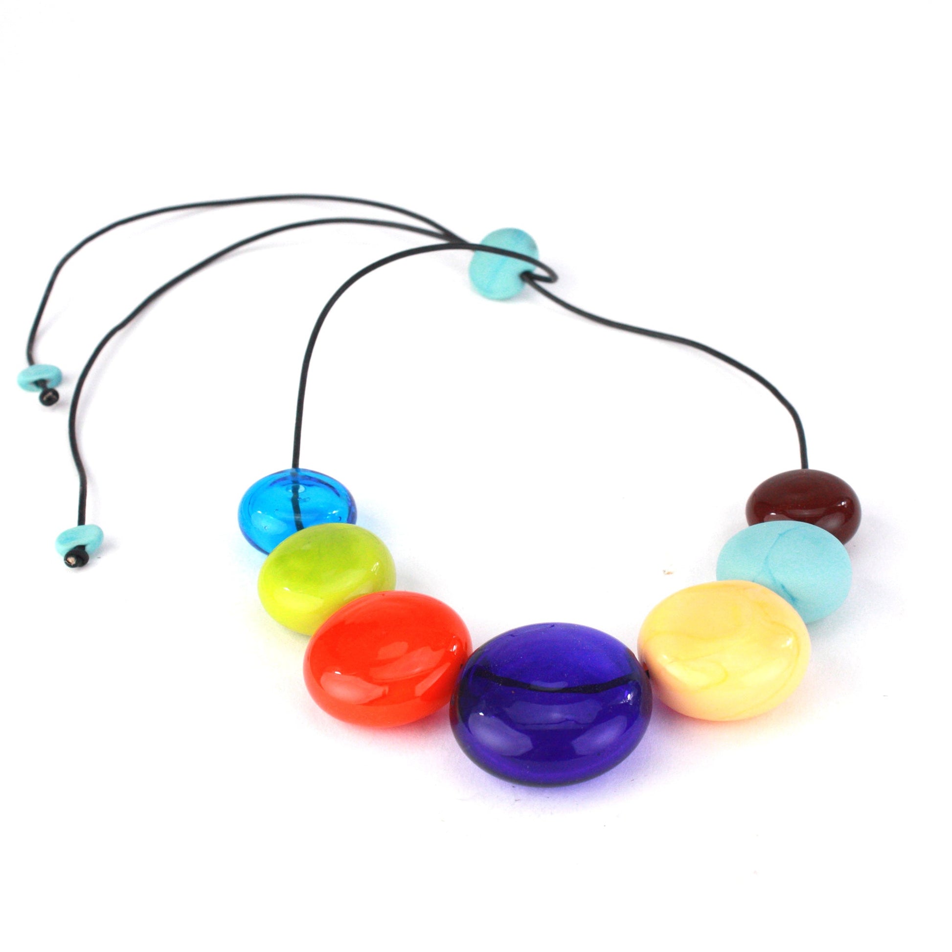 A vibrant necklace featuring seven hollow, hand-blown glass beads in bright multi-colors, strung on adjustable leather for versatile styling options.