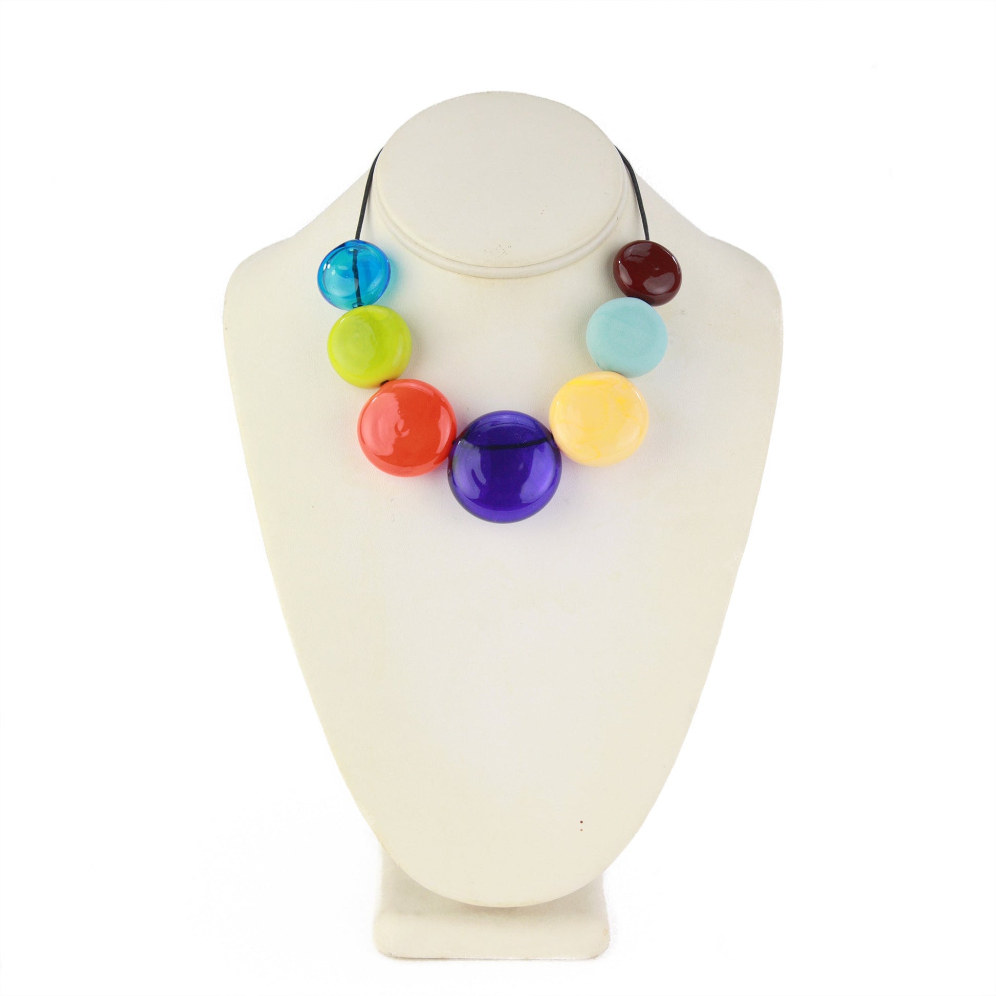 A vibrant necklace featuring seven hollow, hand-blown glass beads in bright multi-colors, strung on adjustable leather for versatile styling options.