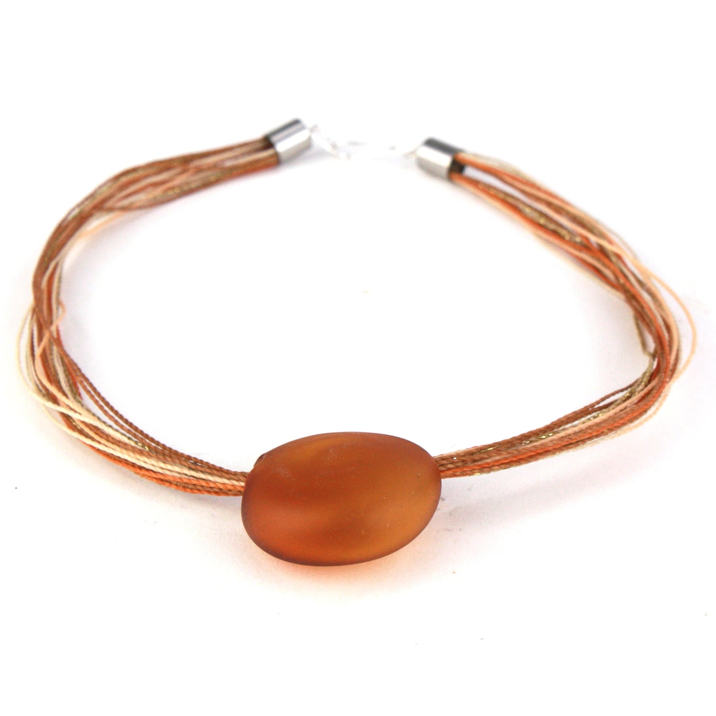 A necklace featuring a hand-blown amber glass focal bead strung on colorful multi-strand waxed cord. Finished with a sterling silver hook-and-loop clasp, this elegant piece combines warm tones with artisanal craftsmanship.