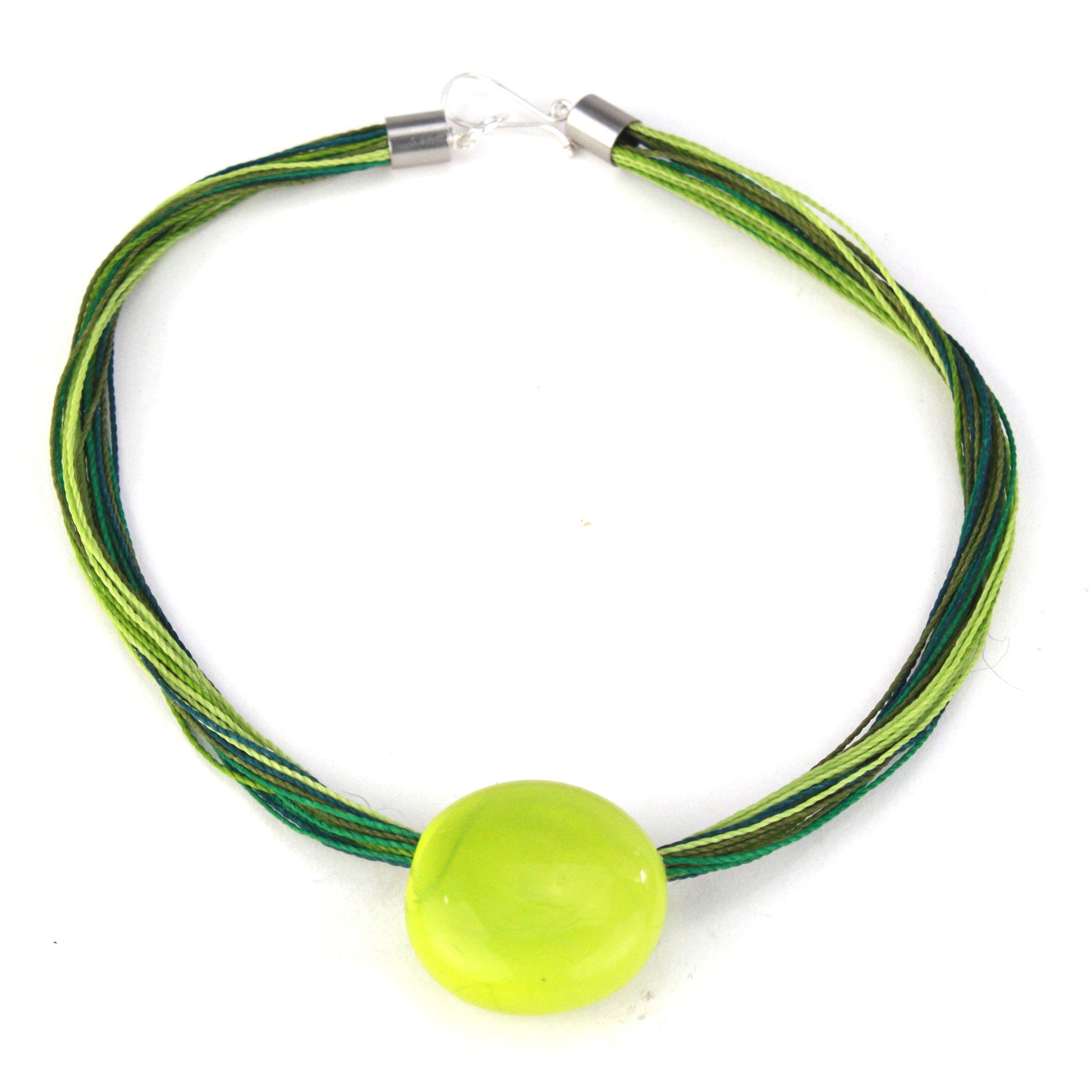 A vibrant necklace featuring a hand-blown green glass focal bead strung on multi-strand waxed cord in shades of green. Finished with a sterling silver hook-and-loop clasp, this piece adds a fresh, colorful accent to any outfit.