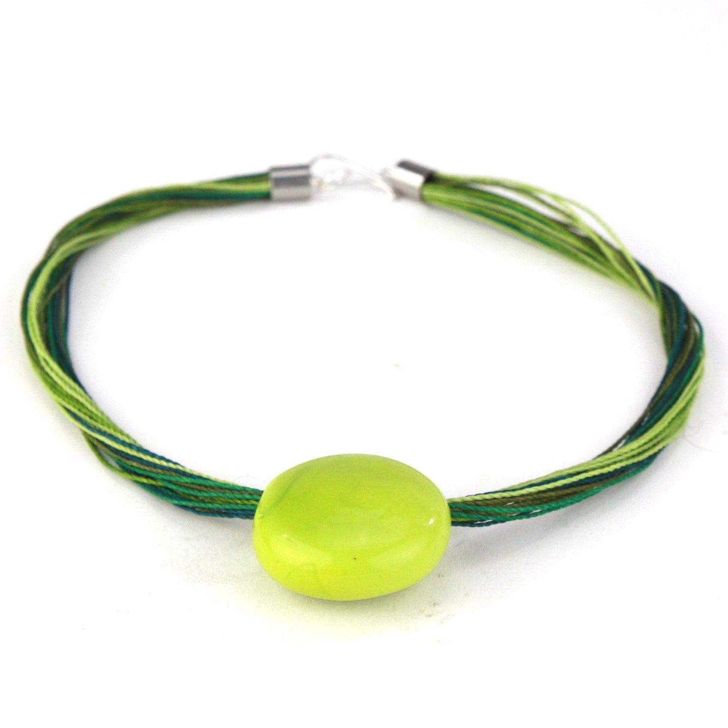 A vibrant necklace featuring a hand-blown green glass focal bead strung on multi-strand waxed cord in shades of green. Finished with a sterling silver hook-and-loop clasp, this piece adds a fresh, colorful accent to any outfit.