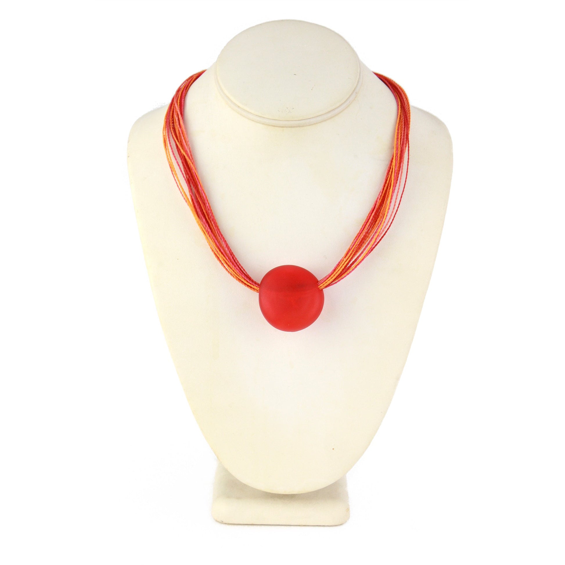 A vibrant necklace featuring a hand-blown orange glass focal bead strung on multi-strand waxed cord in warm orange and tangerine tones. Finished with a sterling silver hook-and-loop clasp, this piece adds a bold and colorful touch to any outfit.