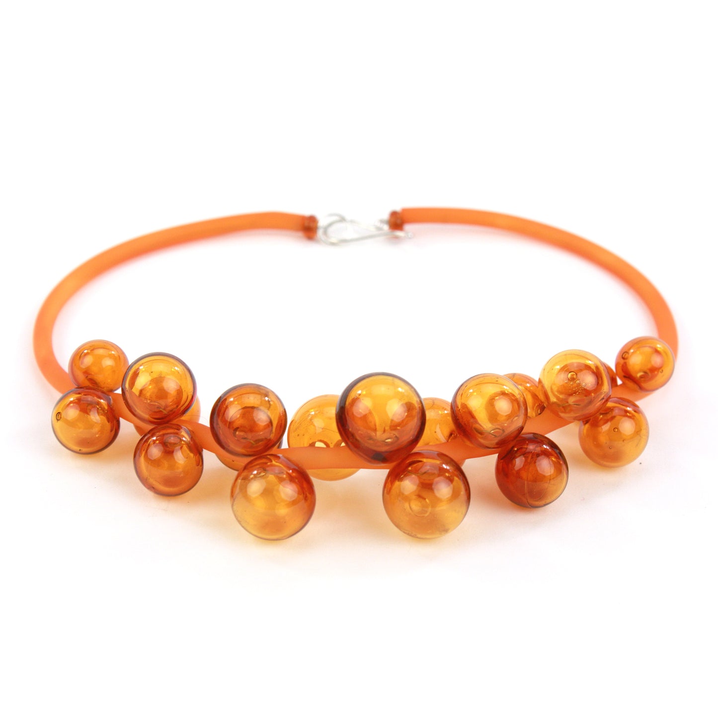 An amber Chroma necklace featuring a cluster of handmade glass beads strung on steel and threaded through a hand-dyed silicone cord with a sterling silver clasp.