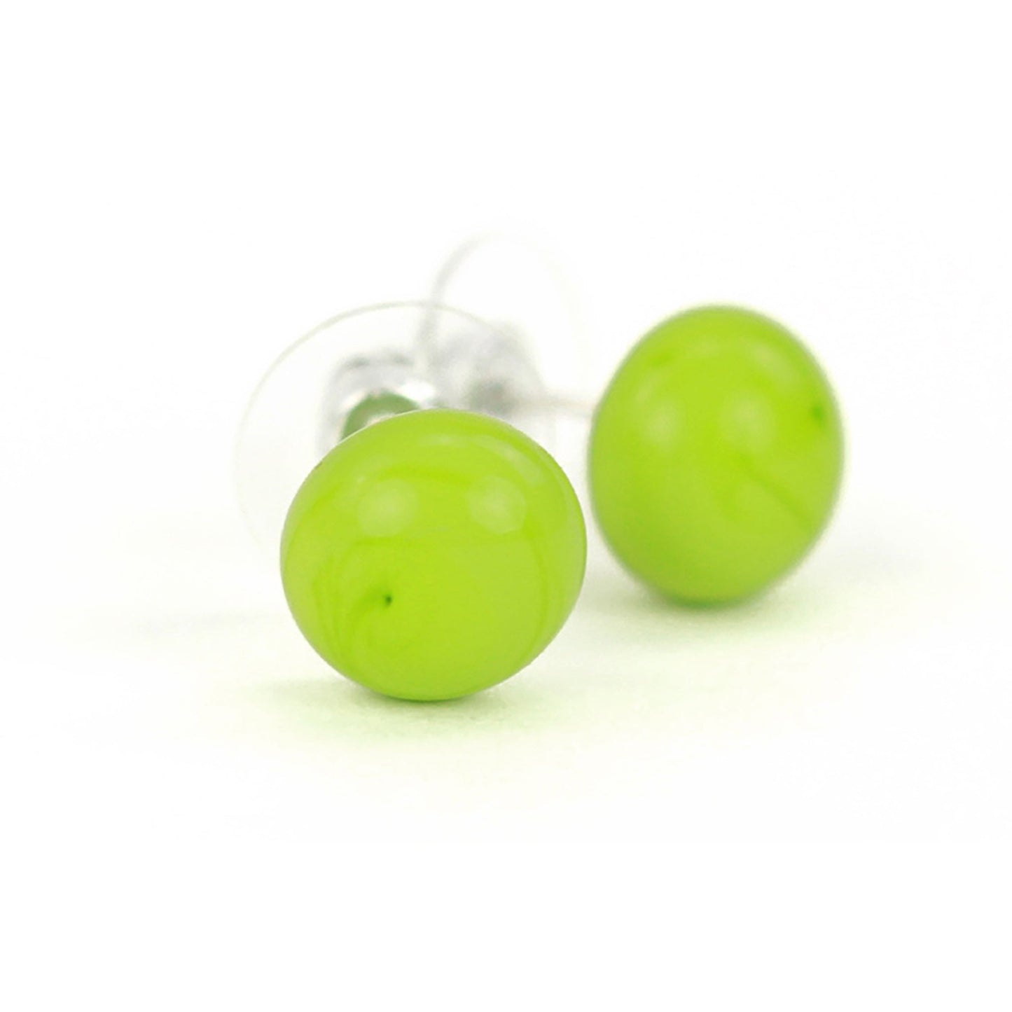 Pair of small bright green glass stud earrings with glossy finish and sterling silver posts, paired with clear earring backs.