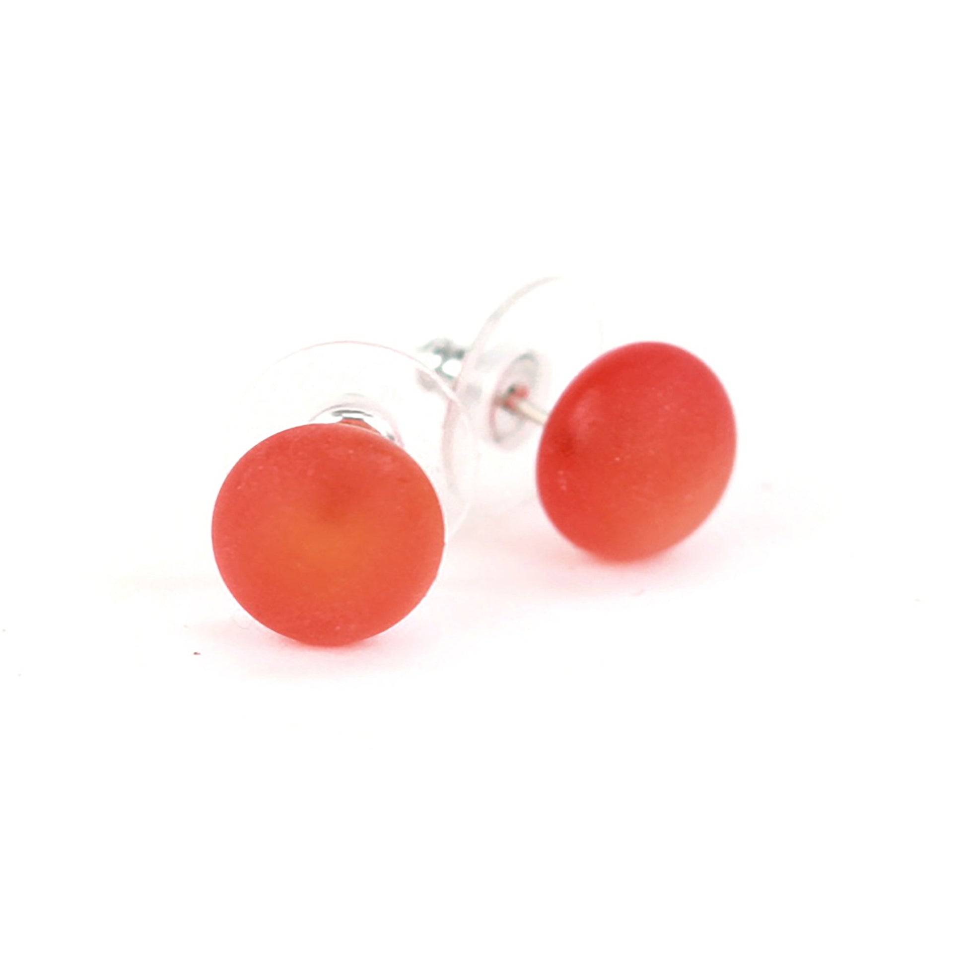 Small frosted orange glass stud earrings with a matte finish and sterling silver posts, paired with clear earring backs.