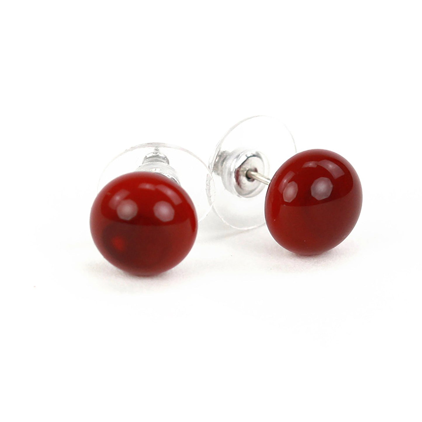 Small ruby red glass stud earrings with a glossy finish and sterling silver posts, paired with clear earring backs.
