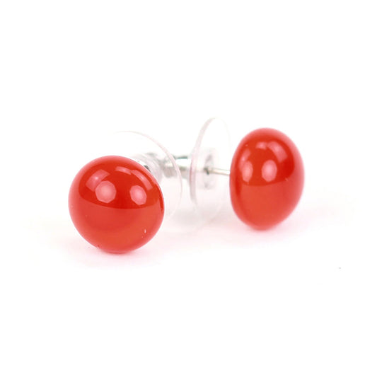 Small bright orange glass stud earrings with a glossy finish and sterling silver posts, paired with clear earring backs.