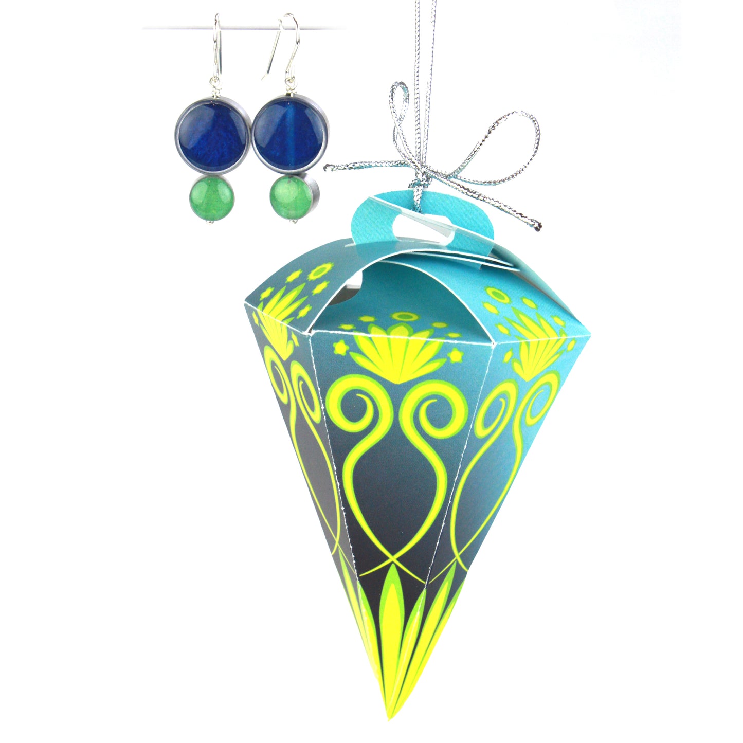 A pair of double-circle earrings in blue and green displayed alongside a blue and green festive ornament box, designed for hanging on a tree.