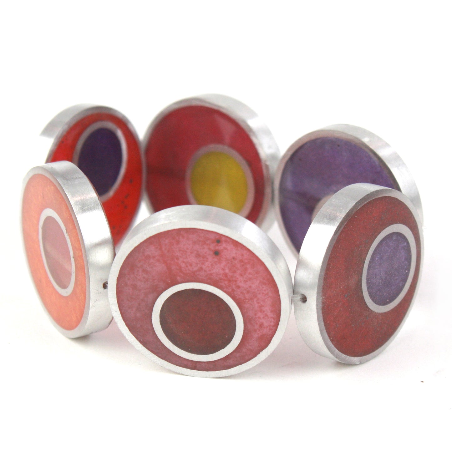 Resinique Double Circle Bracelet with warm tones of red, orange, and purple eco-resin layered in salvaged aluminum circles, strung on a flexible elastic band.