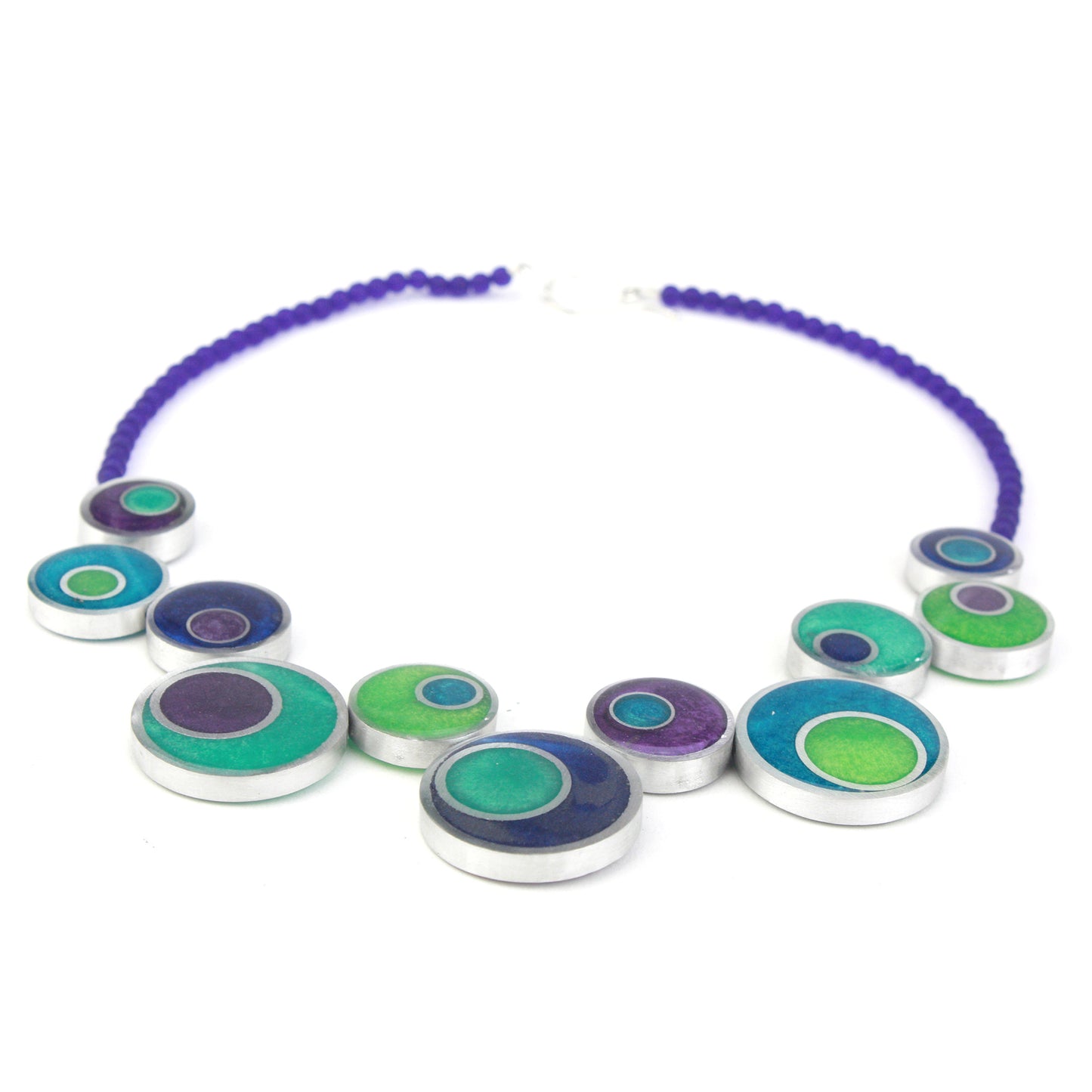 The Resinique Offset Necklace in vibrant blues and greens brings a refreshing, modern twist to sustainable design. Crafted from eco-resin and salvaged aluminum, its playful offset circular beads are strung on bold purple glass beads, creating a statement piece that captures the essence of nature’s vivid colors.
Handcrafted with eco-resin and salvaged aluminum for a sustainable, artistic design.
Features soothing blues and greens inspired by nature, accented with soft purple tones.
Offset circular arrangeme