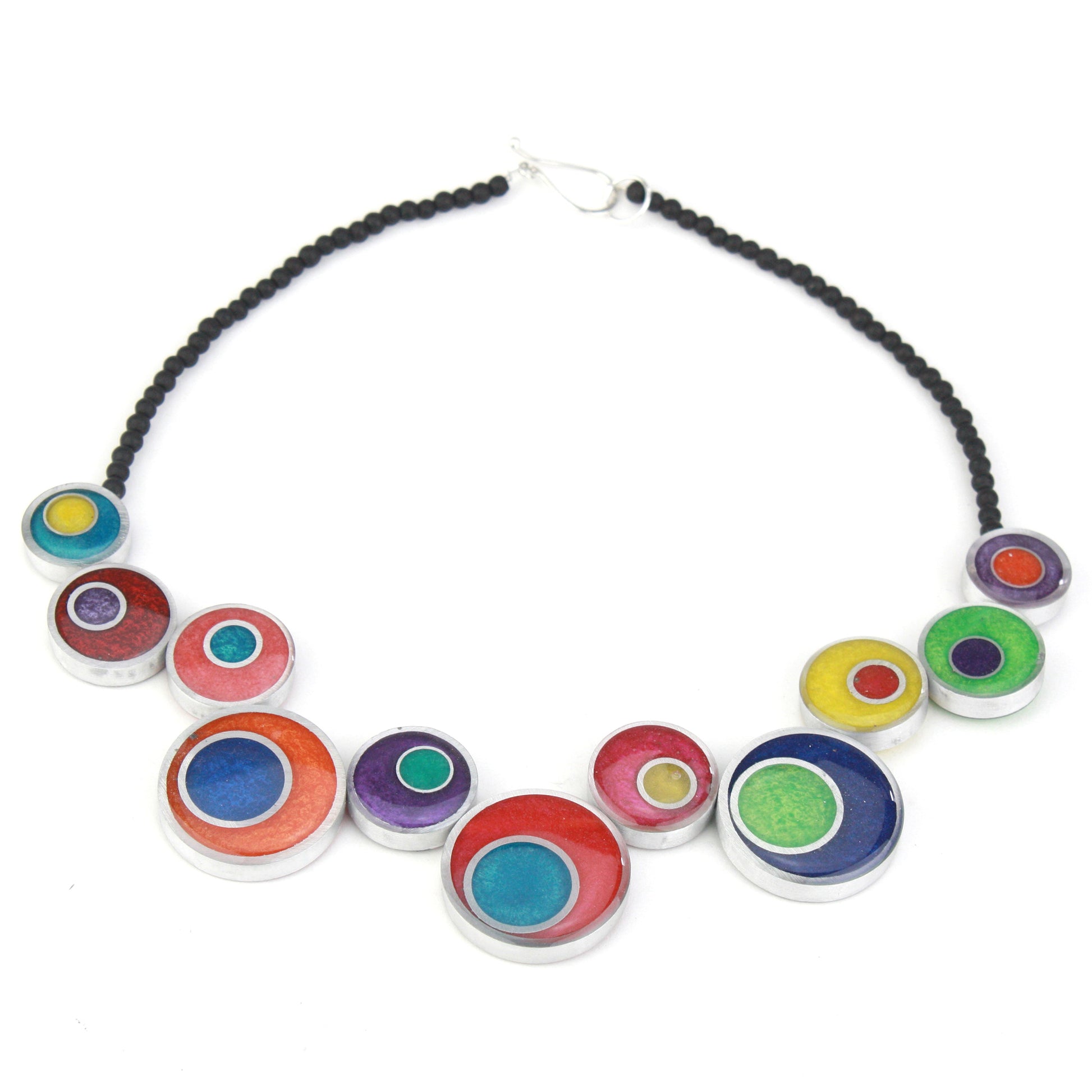 A colorful handcrafted offset necklace with eco-resin and salvaged aluminum beads in red, blue, yellow, green, and purple, finished with black glass beads.