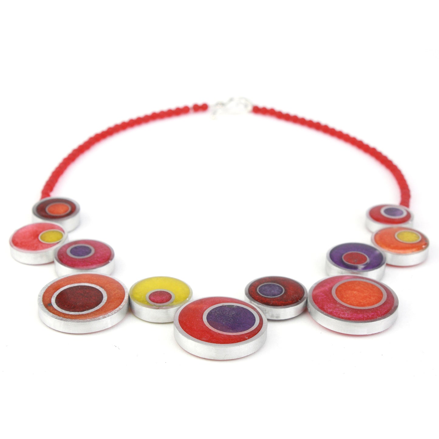 A handcrafted offset necklace featuring eco-resin and salvaged aluminum beads in red, orange, yellow, and purple, strung on red glass beads with a silver clasp.