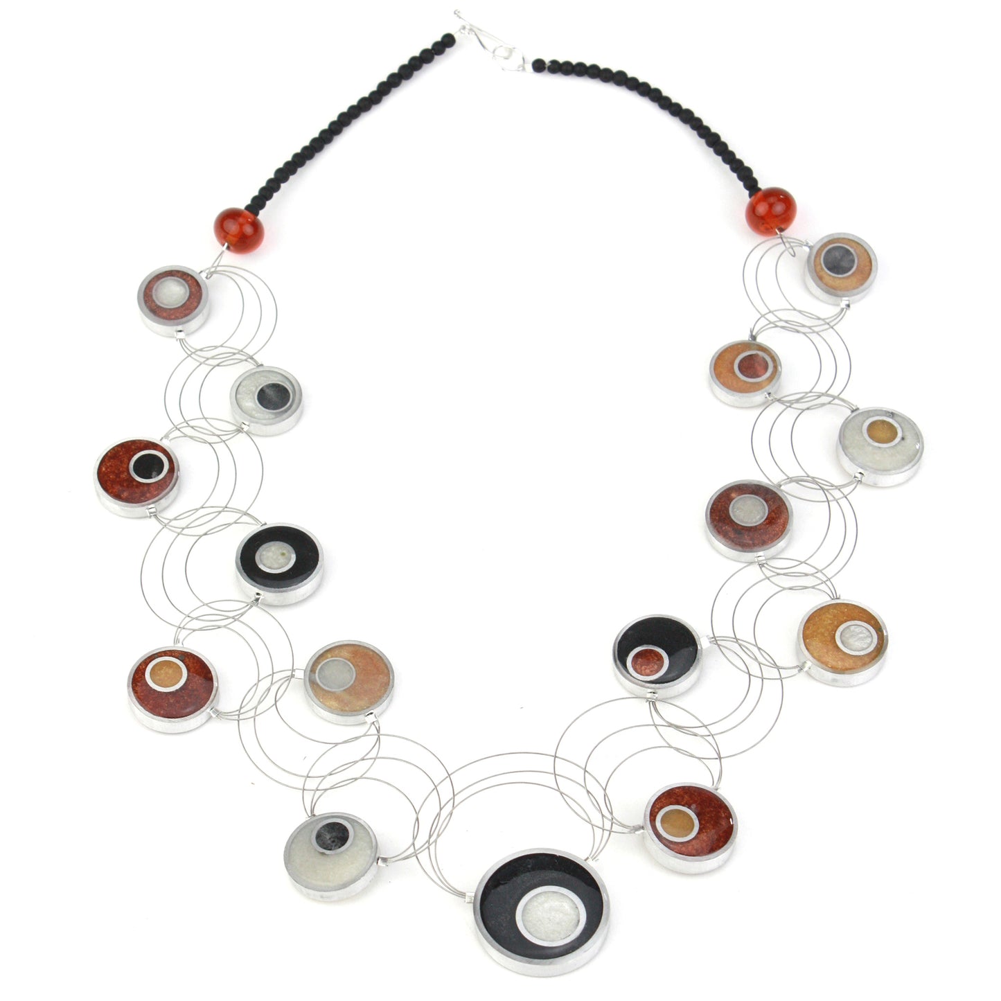 Resinique Interplay Necklace featuring intertwining steel cables with black, white, copper, and gold eco-resin circles and salvaged aluminum accents.
