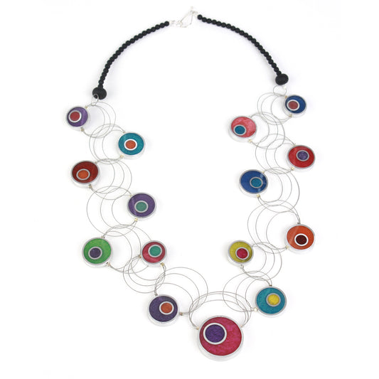 A handcrafted necklace with intertwining steel cables featuring multi-colored eco-resin and salvaged aluminum beads in vibrant shades of red, purple, green, blue, and orange.