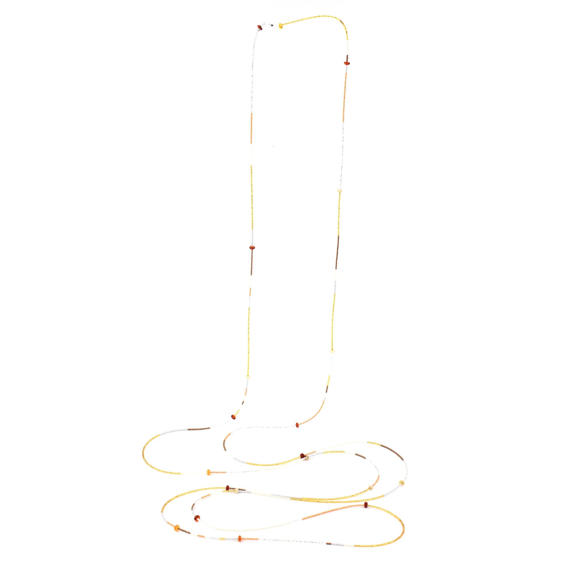 A 12-foot necklace crafted with tiny glass seed beads in warm golden, amber, and earthy tones, accented by handcrafted lampworked beads. Featuring a secure barrel screw clasp, this versatile piece can be styled as a layered necklace or wrapped around the wrist as a bracelet.