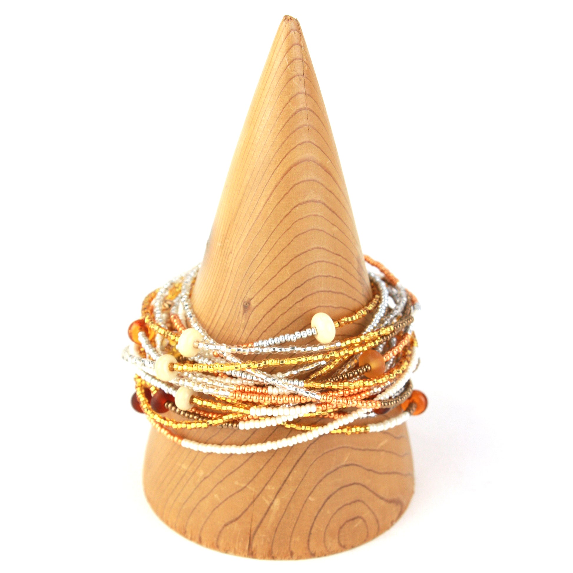 A 12-foot necklace crafted with tiny glass seed beads in warm golden, amber, and earthy tones, accented by handcrafted lampworked beads. Featuring a secure barrel screw clasp, this versatile piece can be styled as a layered necklace or wrapped around the wrist as a bracelet.