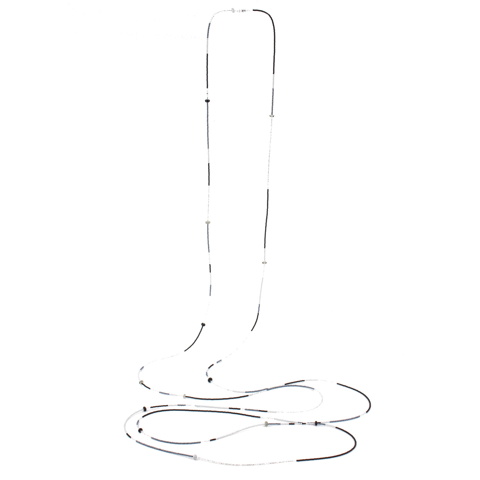 A 12 foot long, multi-strand necklace featuring a mix of black, white, and silver glass seed beads, accented with handcrafted lampworked glass beads. The necklace is secured with a barrel screw clasp and offers a versatile, elegant design perfect for layering or wearing long.