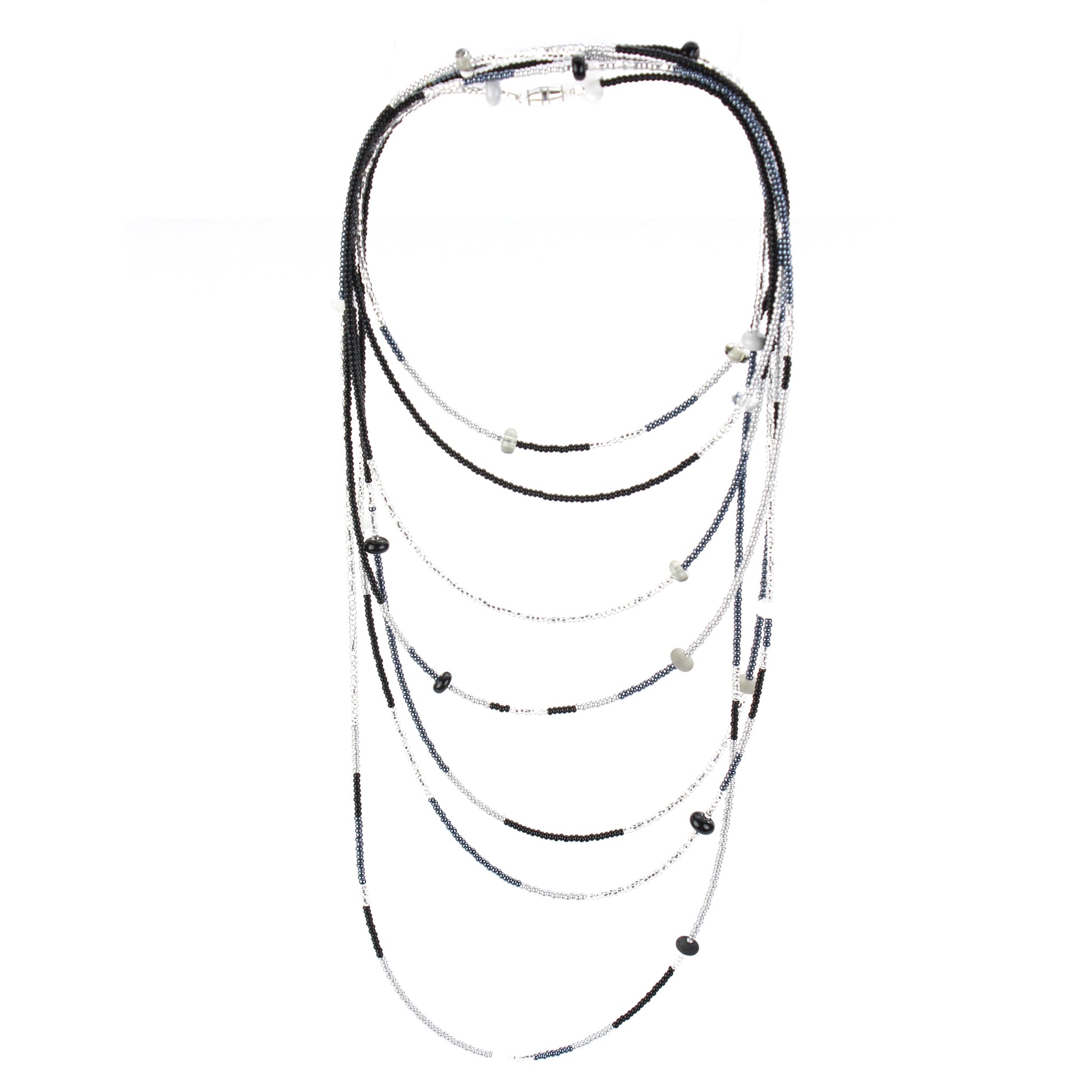 A long, multi-strand necklace featuring a mix of black, white, and silver glass seed beads, accented with handcrafted lampworked glass beads. The necklace is secured with a barrel screw clasp and offers a versatile, elegant design perfect for layering or wearing long.