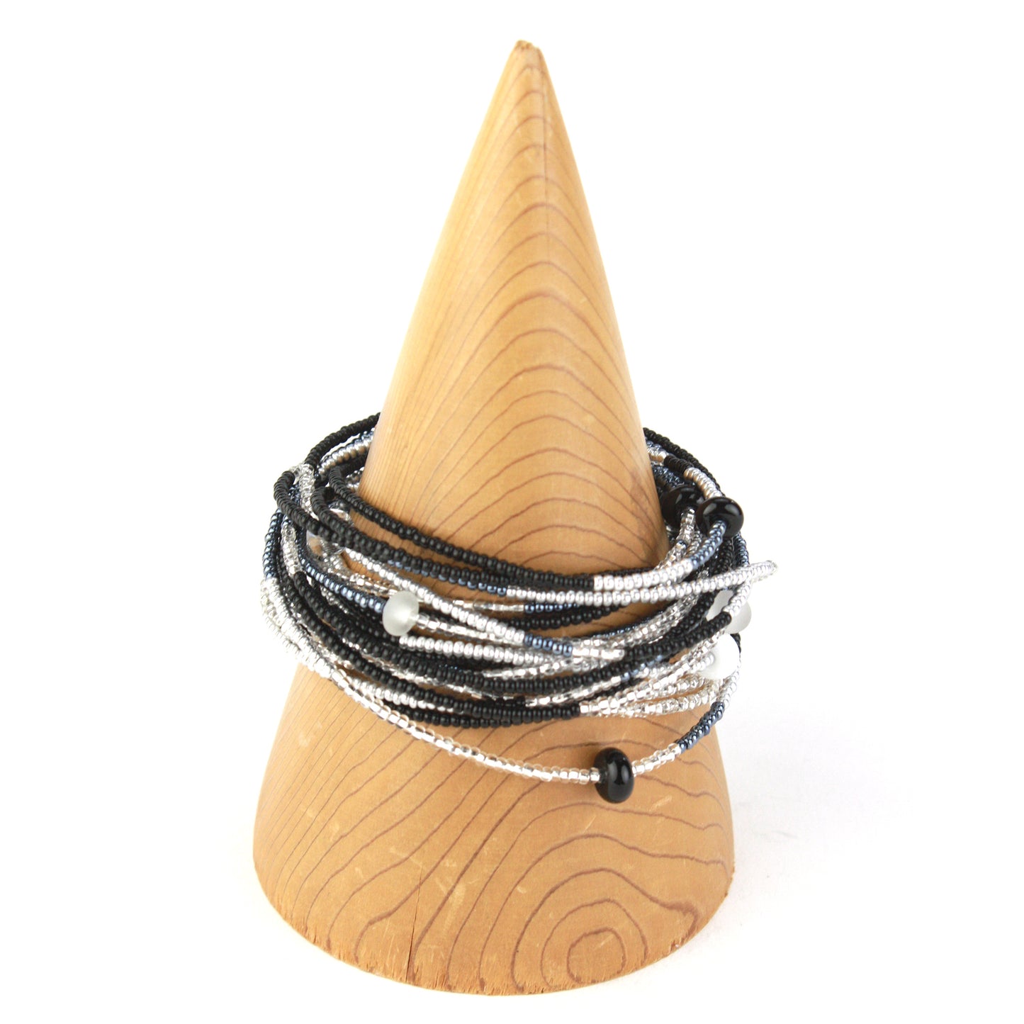 A 12-foot necklace made of black, white, and silver glass seed beads with handcrafted accents, styled here as a wrap bracelet. Its versatile design allows it to be worn as a long necklace, layered, or wrapped around the wrist for a bold bracelet look.