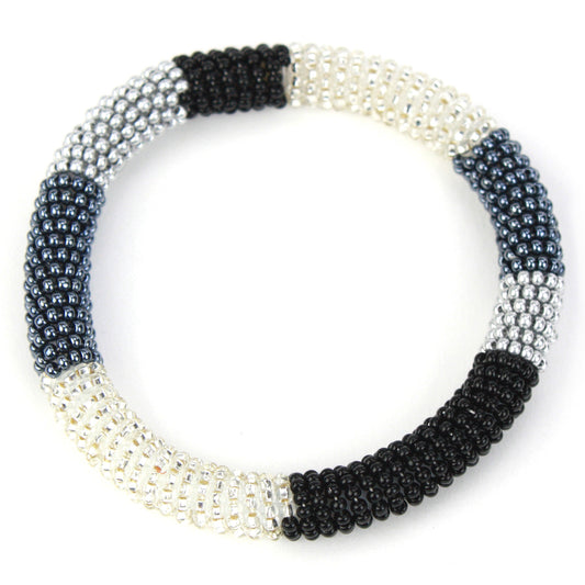 A sleek bangle bracelet made with tiny glass beads in black, silver, and white tones, wrapped around a flexible silicone core for easy slip-on wear.