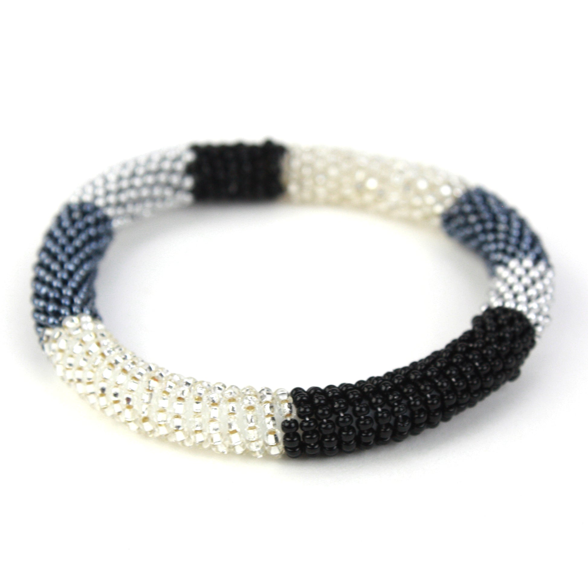 A sleek bangle bracelet made with tiny glass beads in black, silver, and white tones, wrapped around a flexible silicone core for easy slip-on wear.