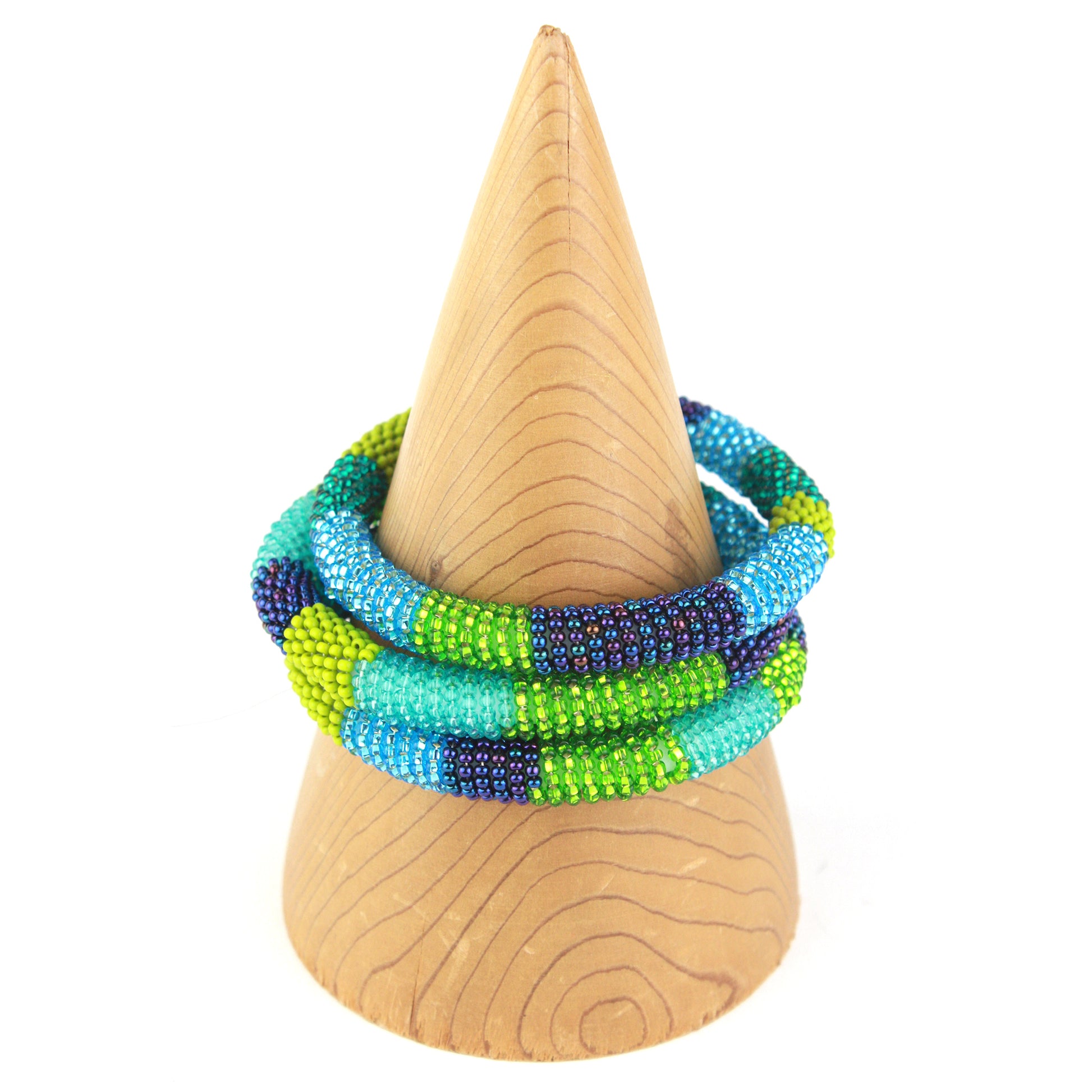 A vibrant bangle bracelet featuring tiny glass beads in shades of blue, teal, green, and purple, wrapped around a flexible silicone core for easy slip-on wear.