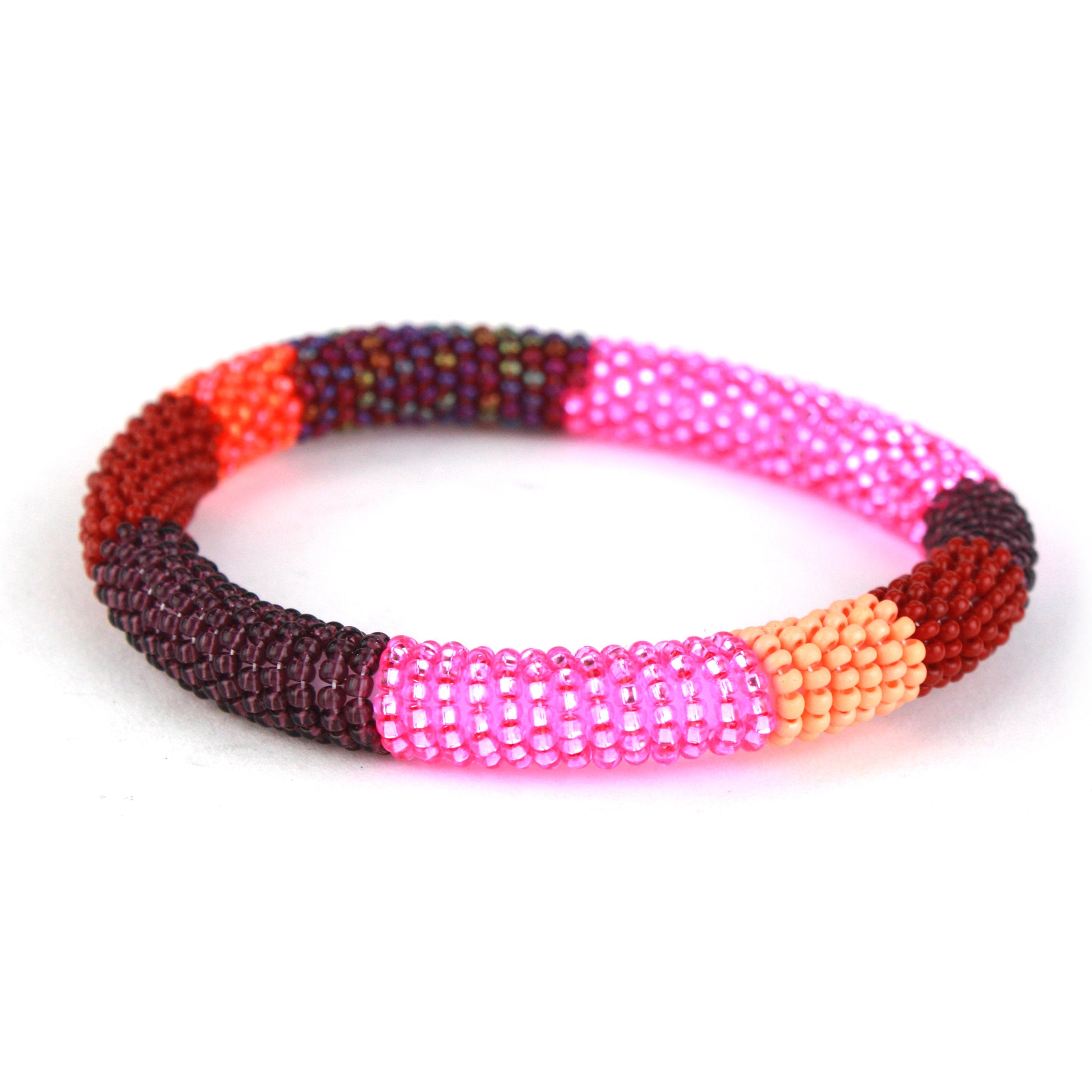 A bold bangle bracelet featuring tiny glass beads in shades of pink, red, maroon, and orange, wrapped around a flexible silicone core for effortless wear.
