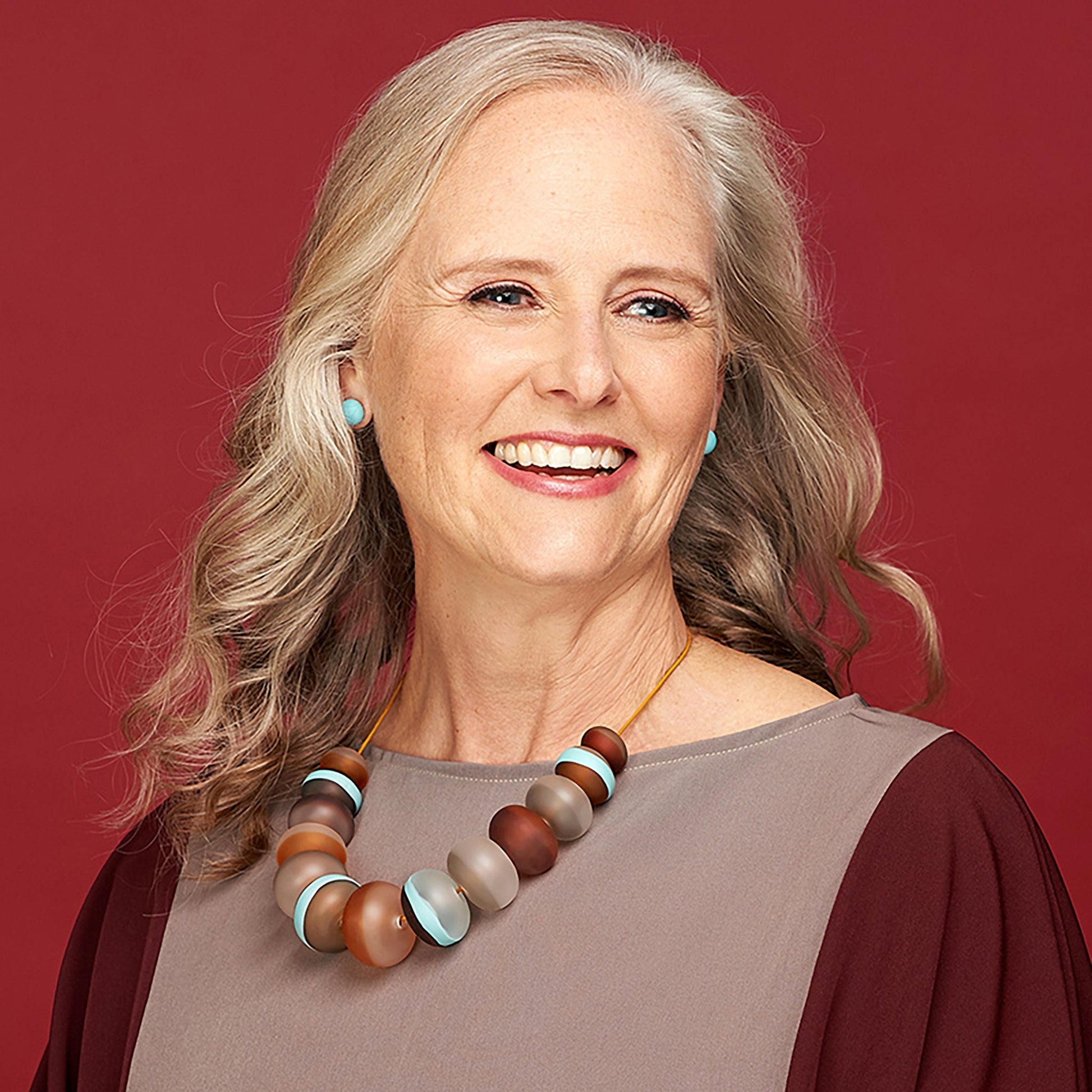 Soft Stripes Necklace with hand-blown sandblasted glass beads in white, grey, amber, and blue hues, strung on an adjustable fine leather cord.