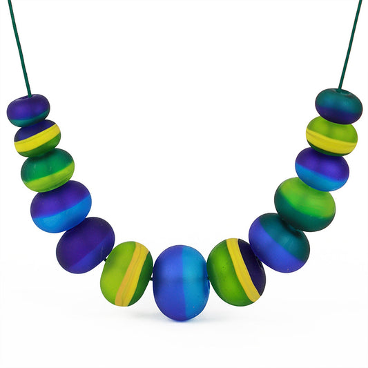 Soft Stripes Necklace with hand-blown, sandblasted glass beads in blues and greens accented by yellow, strung on an adjustable fine leather cord.