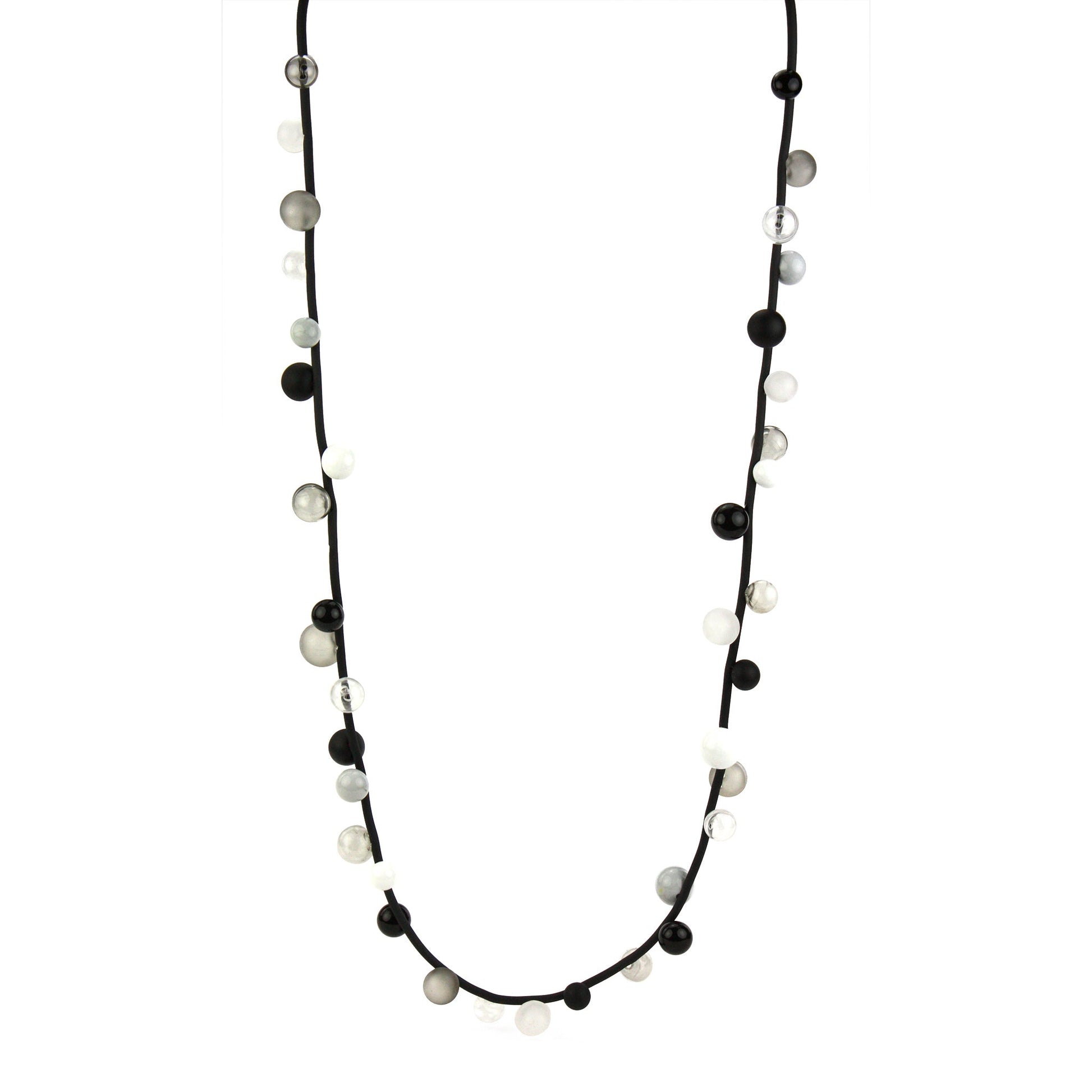 "Bolla" necklace featuring monochrome hand-blown glass beads in black, white, and clear shades, strung on a steel cable with a rubber cord, worn long or doubled.