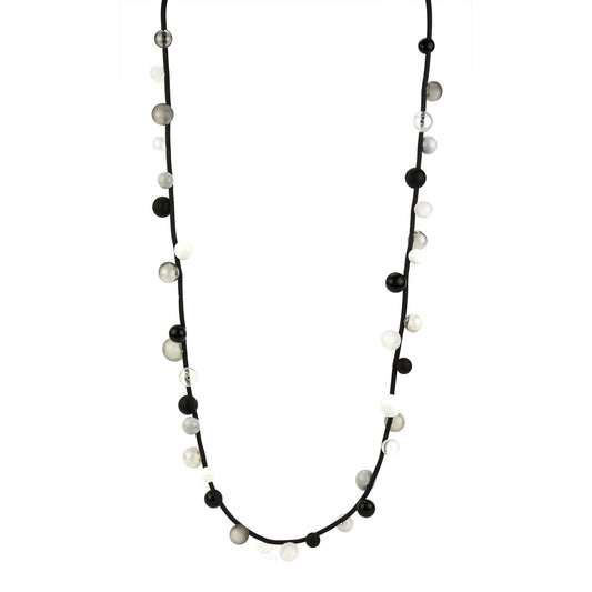"Bolla" necklace featuring monochrome hand-blown glass beads in black, white, and clear shades, strung on a steel cable with a rubber cord, worn long or doubled.