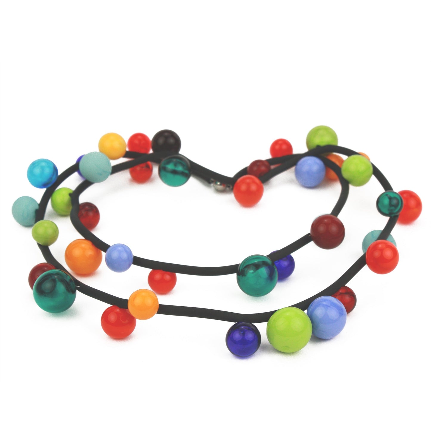 "Bolla" necklace featuring vibrant hand-blown glass beads in rainbow colors, strung on a steel cable threaded through a rubber cord, worn long or doubled.