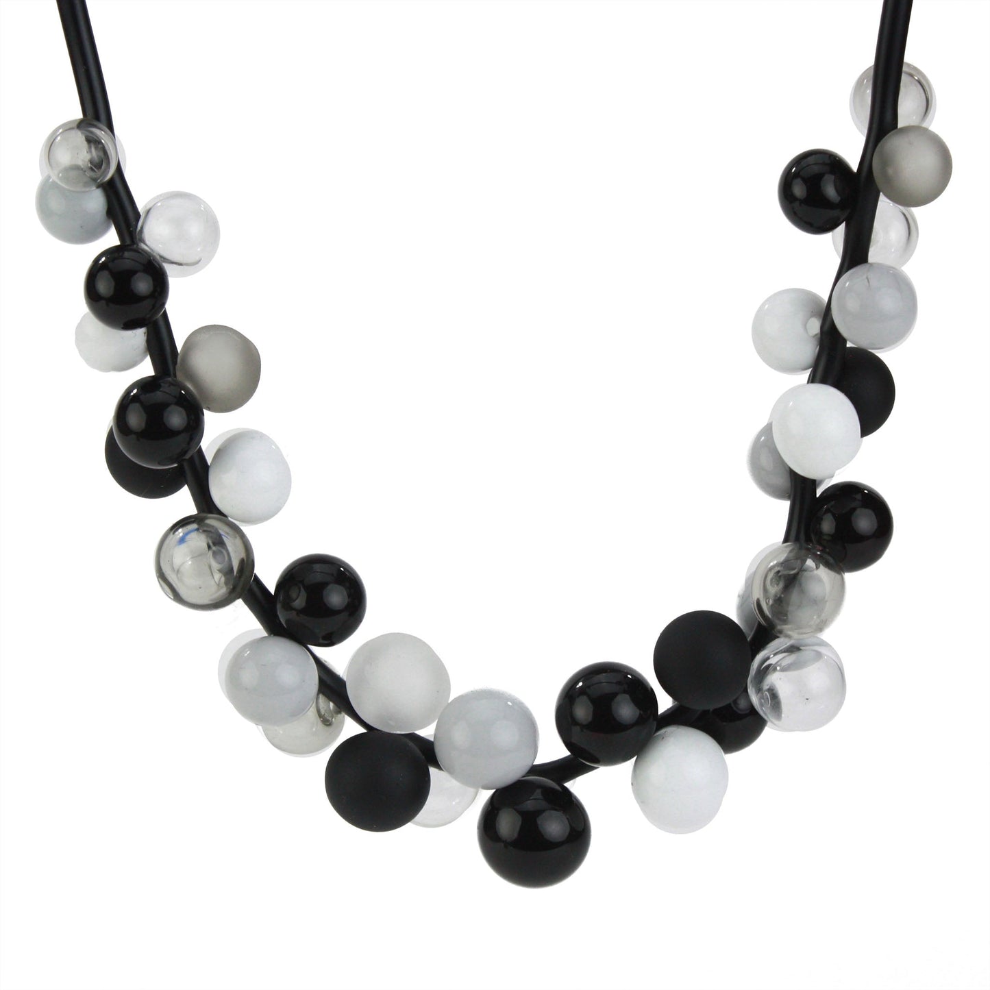 A sophisticated "Bolla" necklace featuring hand-blown glass beads in black, white, and grey tones, strung on steel cable through a rubber cord with a sterling silver clasp.