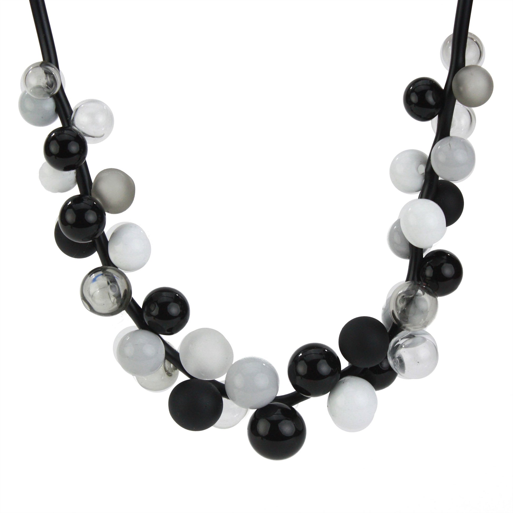 A sophisticated "Bolla" necklace featuring hand-blown glass beads in black, white, and grey tones, strung on steel cable through a rubber cord with a sterling silver clasp.