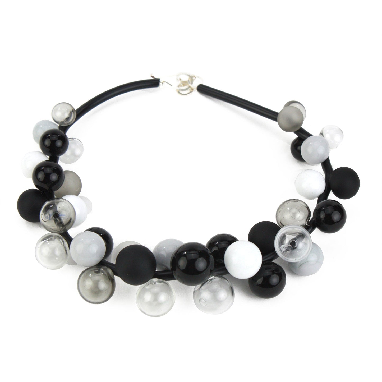 A sophisticated "Bolla" necklace featuring hand-blown glass beads in black, white, and grey tones, strung on steel cable through a rubber cord with a sterling silver clasp.