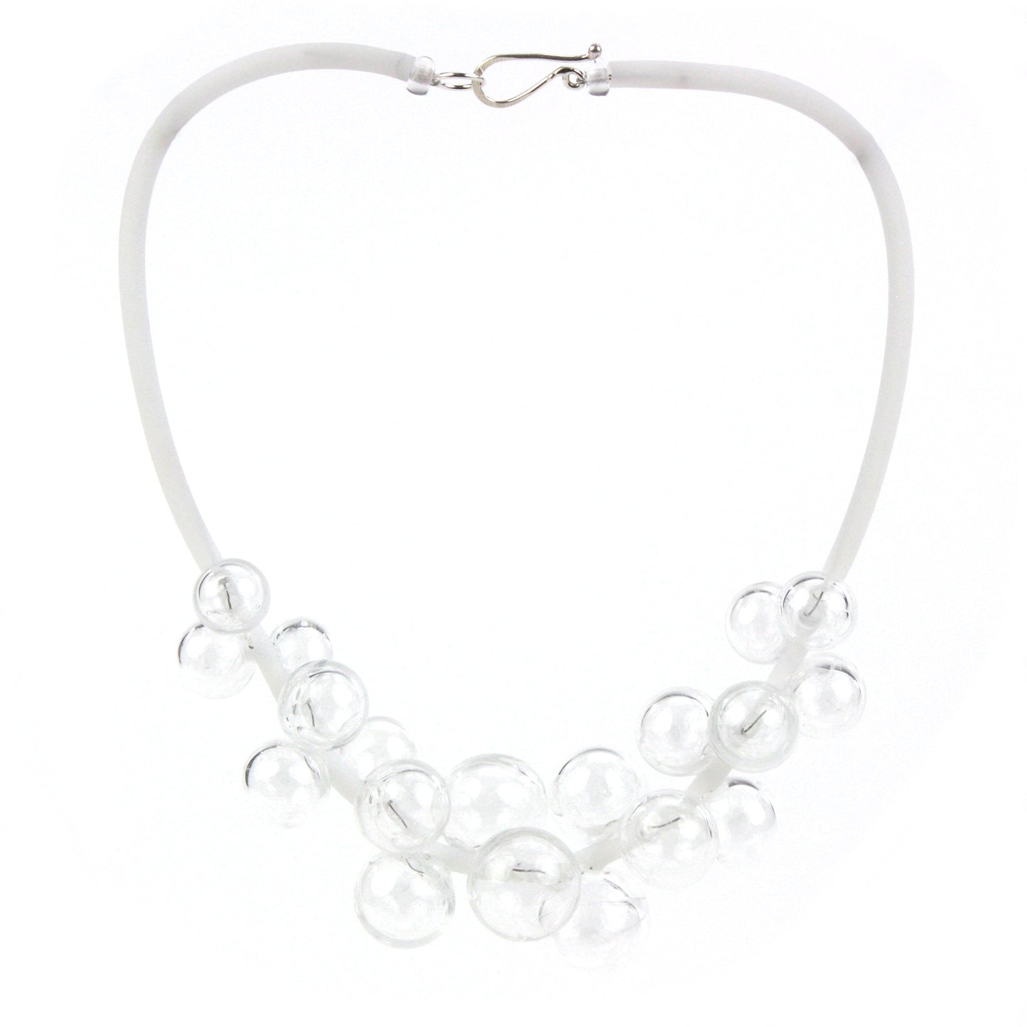 A clear Chroma necklace featuring transparent glass beads clustered on steel wire and threaded through a white hand-dyed silicone cord with a sterling silver clasp.