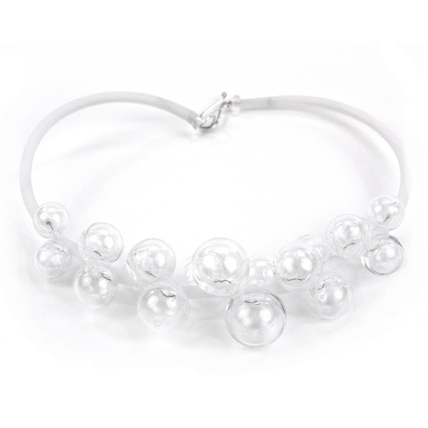 A clear Chroma necklace featuring transparent glass beads clustered on steel wire and threaded through a white hand-dyed silicone cord with a sterling silver clasp.