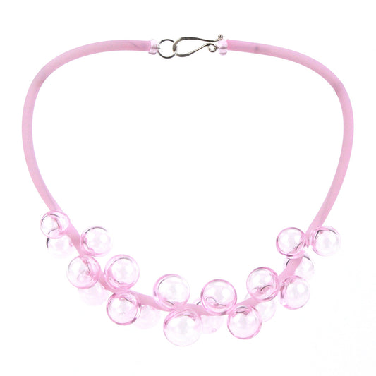 A pastel pink Chroma necklace showcasing clusters of handblown glass beads strung on steel wire and threaded through a hand-dyed pink silicone cord with a sterling silver clasp.