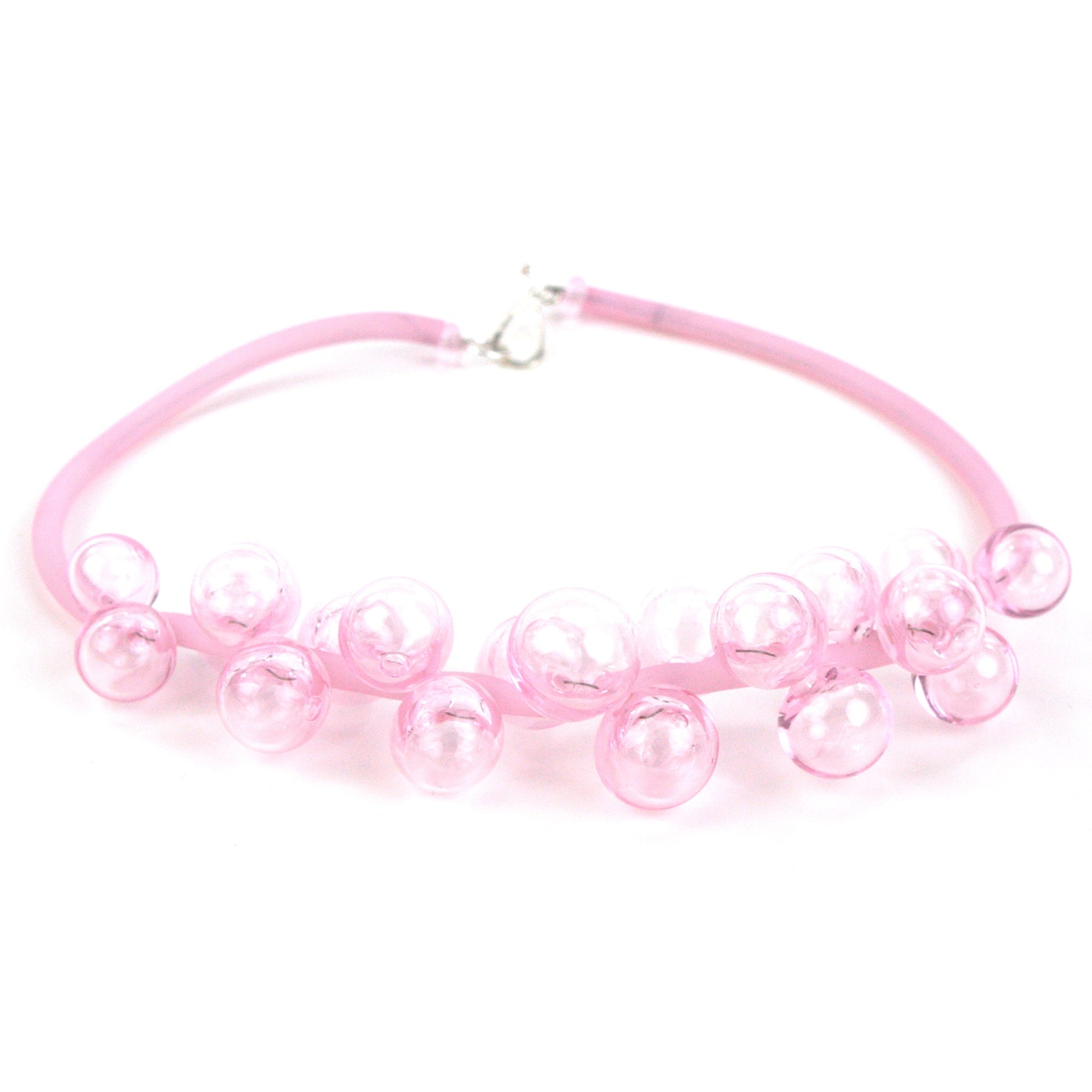 A pastel pink Chroma necklace showcasing clusters of handblown glass beads strung on steel wire and threaded through a hand-dyed pink silicone cord with a sterling silver clasp.