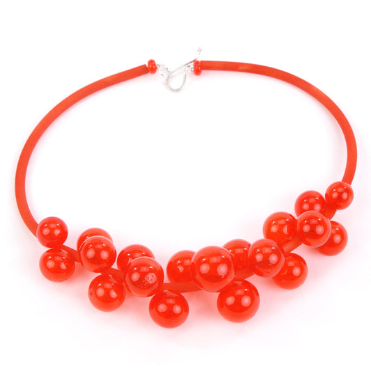 Cherry red Chroma necklace featuring clusters of handblown glass beads strung on steel wire, threaded through a hand-dyed silicone cord with a sterling silver clasp.