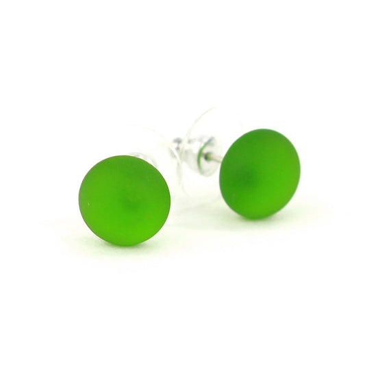 Pair of small frosted spring green glass stud earrings with matte finish and sterling silver posts, paired with clear earring backs.