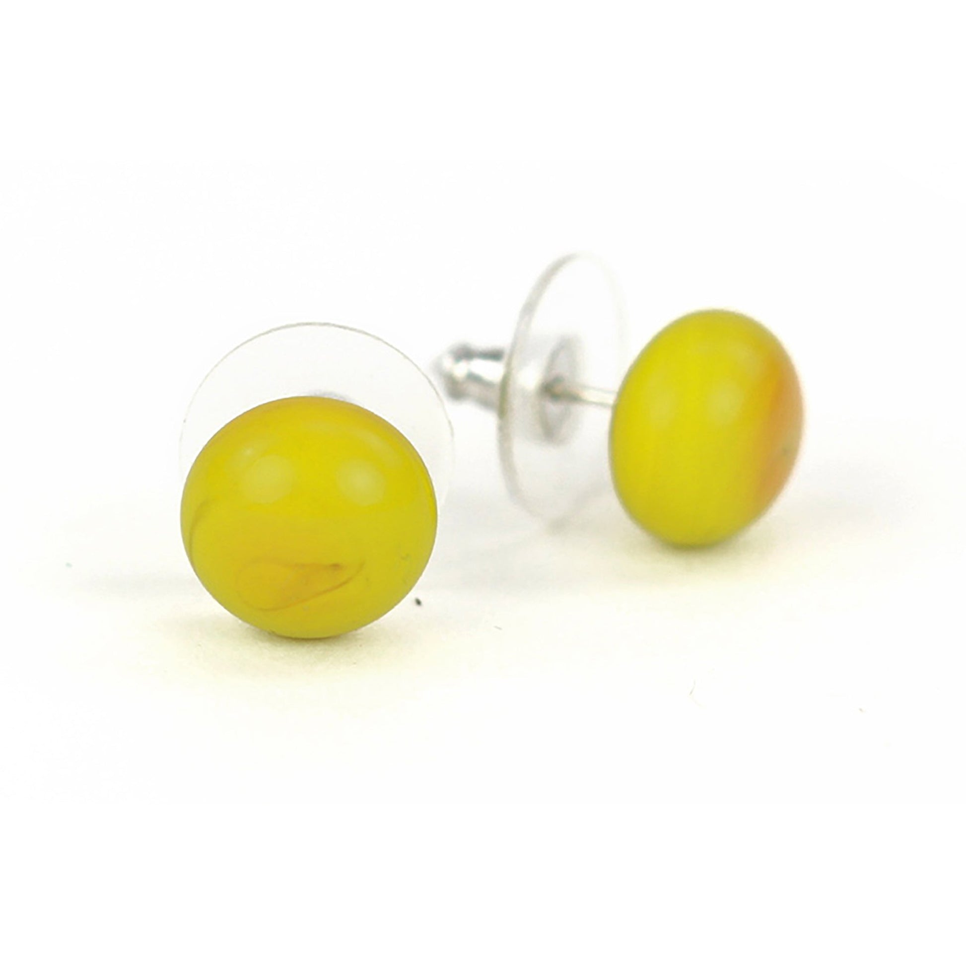 Small yellow ochre glass stud earrings with a glossy finish and sterling silver posts, paired with clear earring backs.