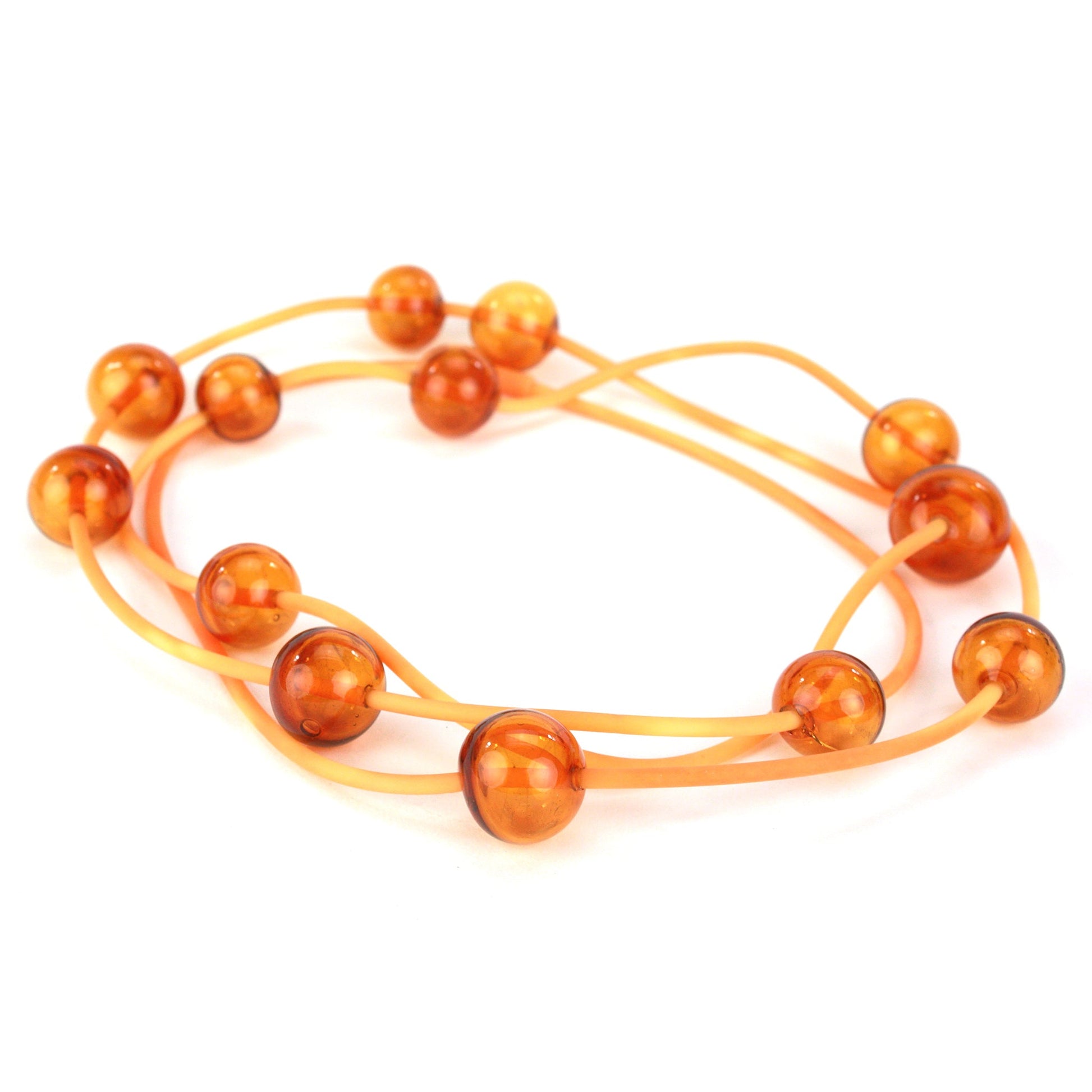 Amber Orbit Necklace with handblown glass beads on a hand-dyed silicone cord, featuring adjustable bead positions and multiple styling options.