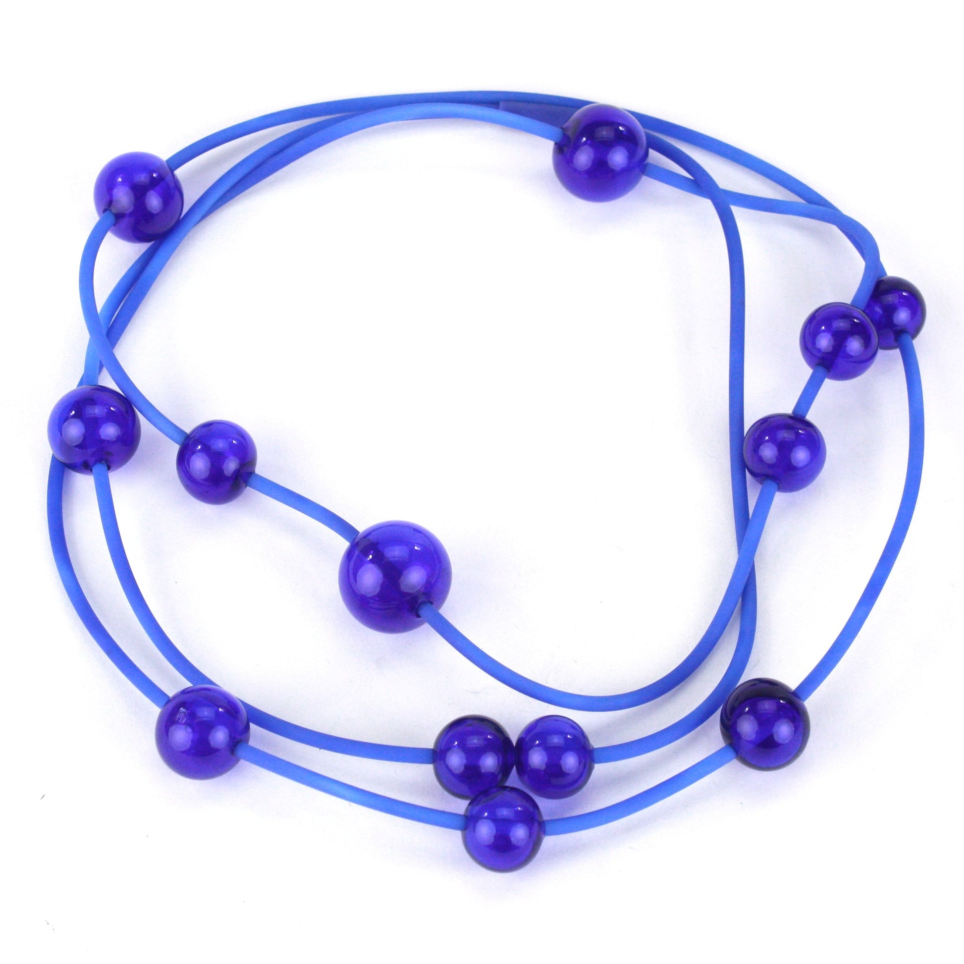 Cobalt Orbit Necklace featuring vibrant handblown glass beads on a hand-dyed silicone cord, adjustable for versatile wear as a long or layered piece.