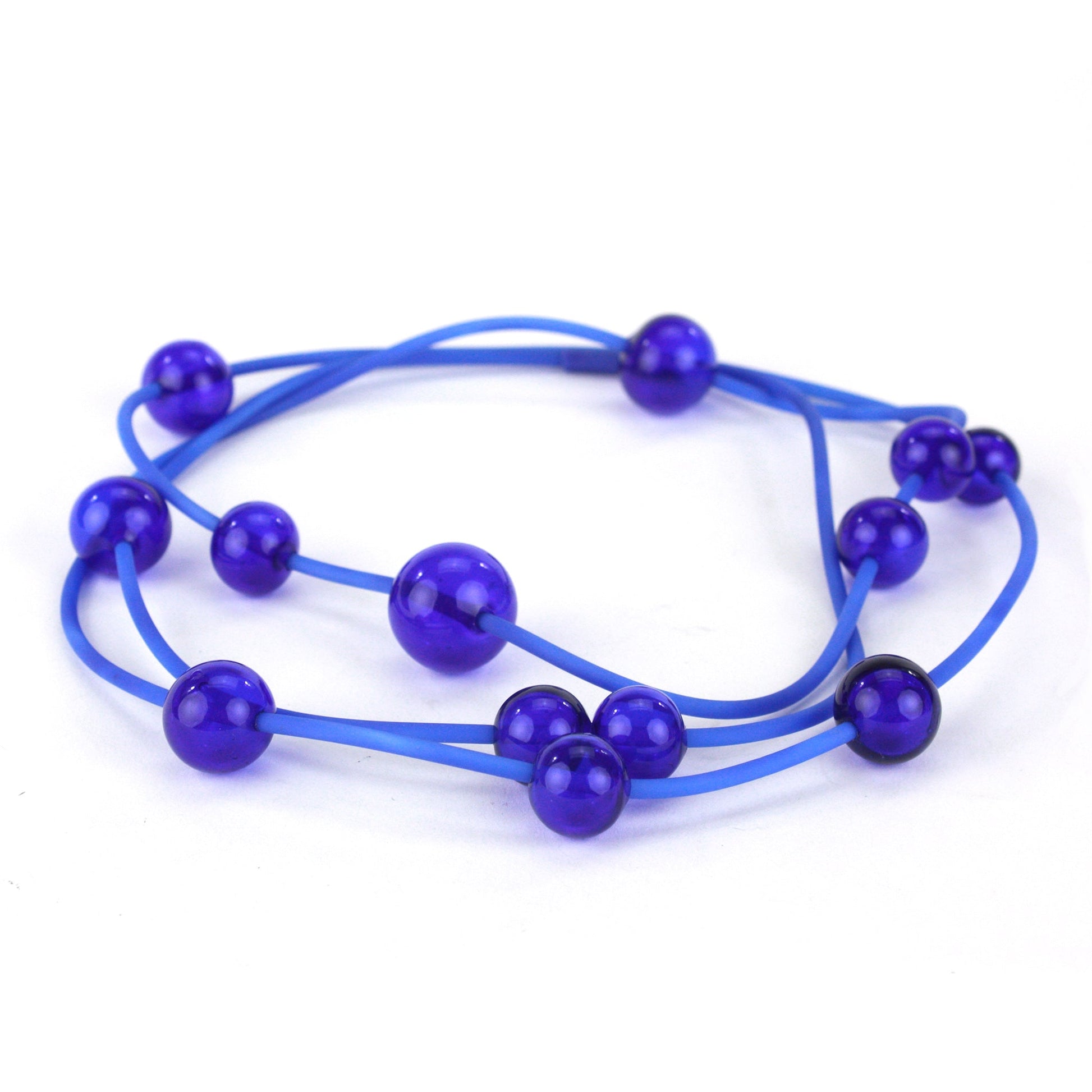 Cobalt Orbit Necklace featuring vibrant handblown glass beads on a hand-dyed silicone cord, adjustable for versatile wear as a long or layered piece.