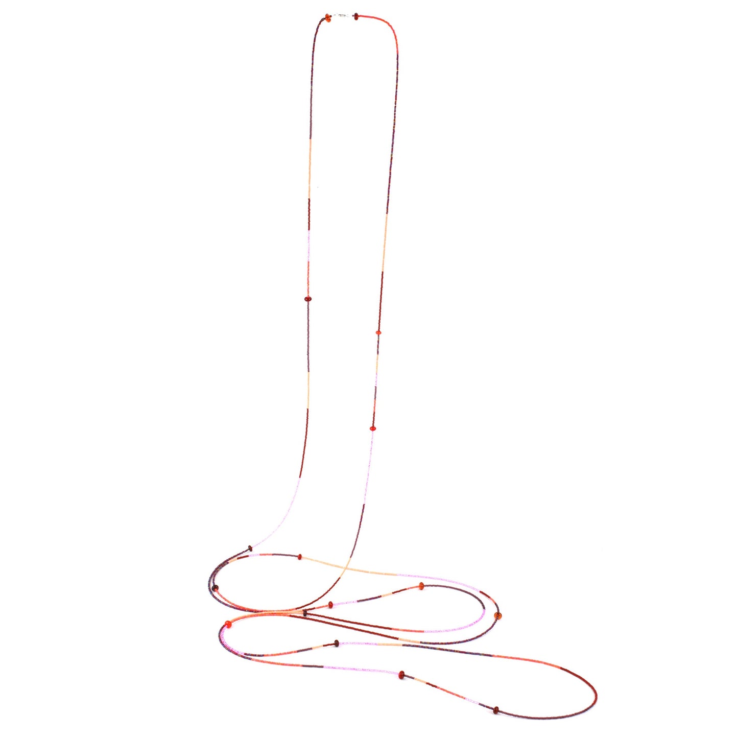 A 12-foot necklace featuring tiny glass seed beads in warm shades of red, orange, and pink, accented with handcrafted lampworked beads. The necklace includes a secure barrel screw clasp and can be styled as a layered necklace or wrapped around the wrist as a bracelet.