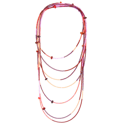 A 12-foot necklace featuring tiny glass seed beads in warm shades of red, orange, and pink, accented with handcrafted lampworked beads. The necklace includes a secure barrel screw clasp and can be styled as a layered necklace or wrapped around the wrist as a bracelet.