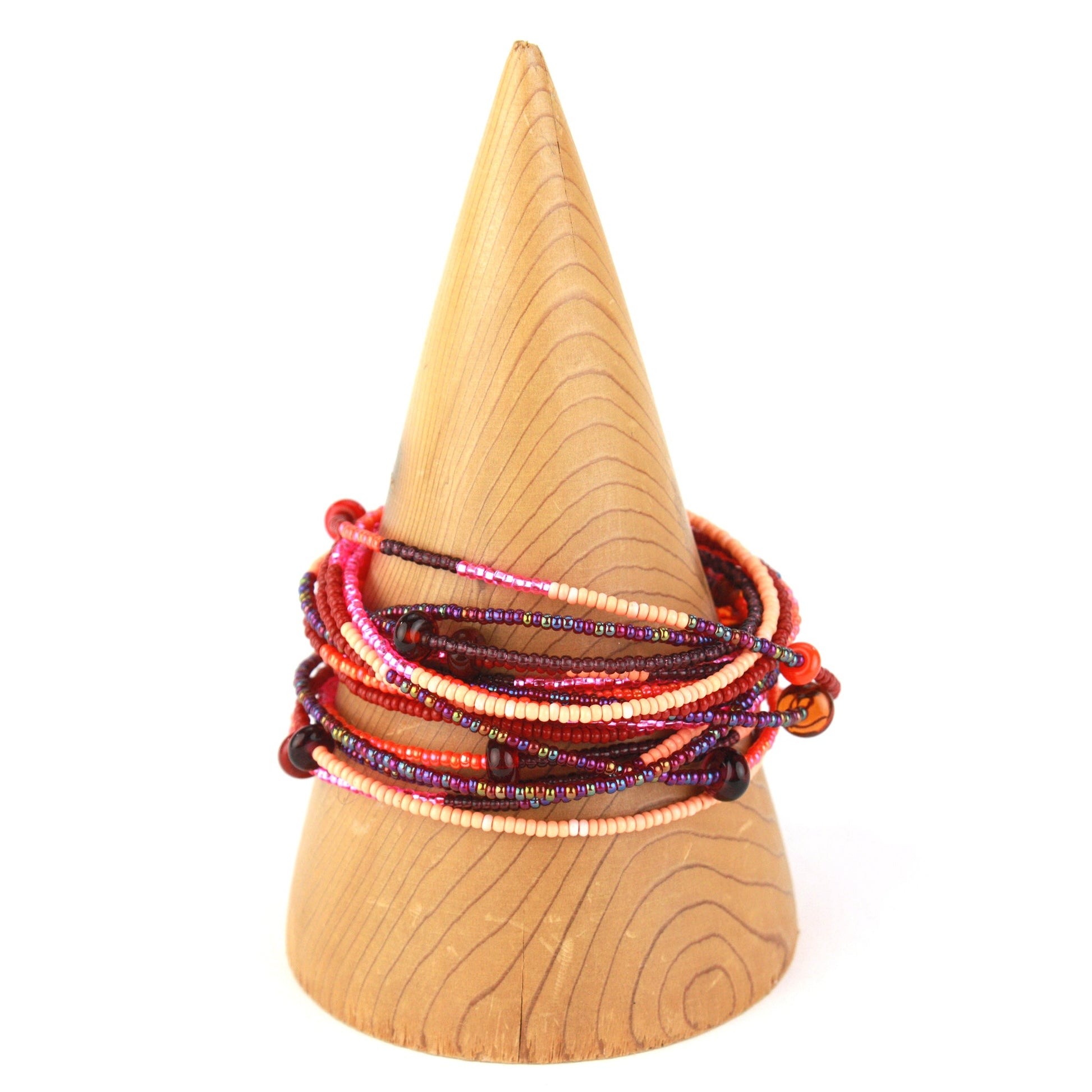 A 12-foot necklace featuring tiny glass seed beads in warm shades of red, orange, and pink, accented with handcrafted lampworked beads. The necklace includes a secure barrel screw clasp and can be styled as a layered necklace or wrapped around the wrist as a bracelet.